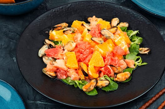 Salad with citrus fruits and mussels, dieting eating. Healthy food concept.