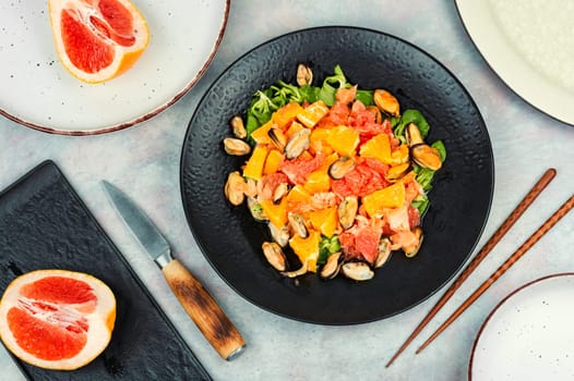 Salad with citrus fruits and mussels, dieting eating. Healthy food concept.