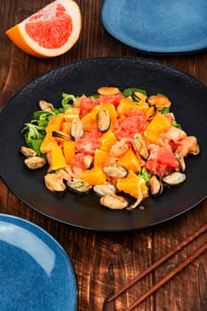 Salad with citrus fruits and mussels, dieting eating. Healthy food concept.