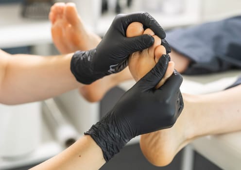Peeling feet pedicure procedure in a beauty salon. Sugar scrub and relax beauty procedure.