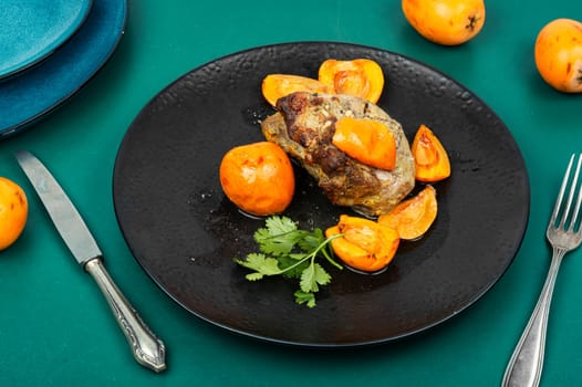 Roasted barbecue tenderloin meat with succulent loquat fruits. Delicious piece of meat roasted with ripe medlar fruit