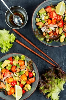 Delicious salad with fresh vegetables and seafood on a plate. Healthy food.