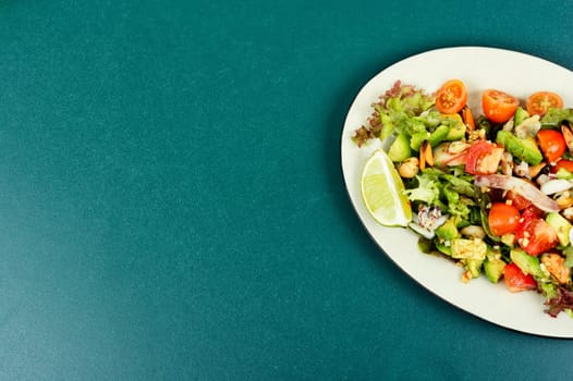 Delicious salad with fresh vegetables and seafood on a plate. Healthy food.