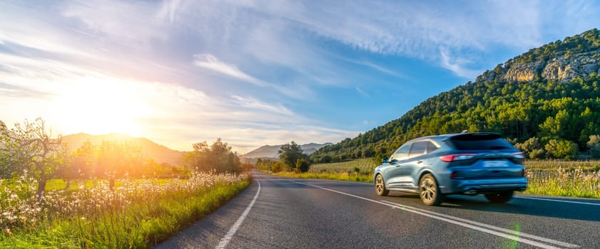 rental car in spain mountain landscape road at sunset. wide angle panorama shot