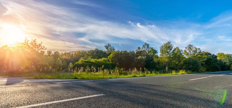 Mediterranean sea coast road into mountains horizon in summer with beautiful bright sun rays - wide angle panorama shot