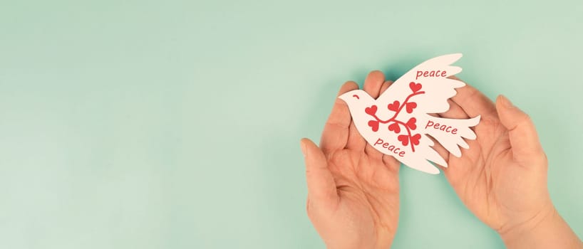 Dove with hearts flying from hand, international peace day, faith, freedom, charity and help concept, humanitarian aid