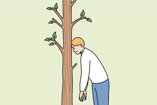 Tired man rests forehead on tree to rest after long walk in fresh air, stands alone in forest. Tired guy feels exhausted and needs sleep to restore energy or strength spent on hike
