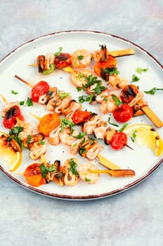 Barbecue or grilled seafood kebabs, shrimps prawns, mussels and grilled squid on skewers. Space for text.