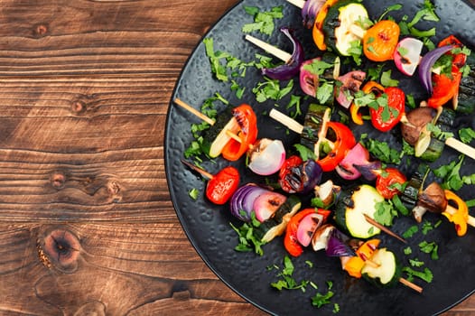 Vegan shashlik of fresh vegetables on wooden skewers. Copy space. Space for text.