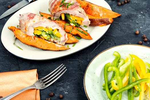 Roasted meat or meat roll, stuffed with peppers, bacon and baked sweet potatoes. Baked meat