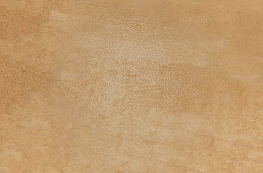 The background texture is a rough brown glossy surface with streaks and spots in close-up