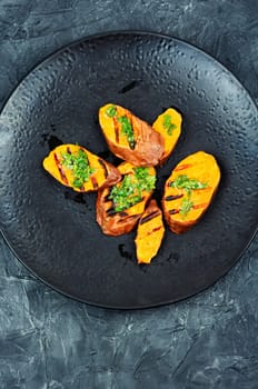 Homemade grilled sweet potato, batata with olive oil and herbs. Vegan cuisine.
