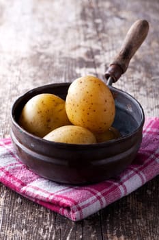four cooked potatoes in an old pan