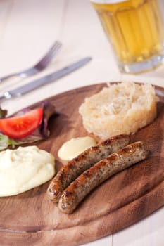 two bratwurst sausages on a wooden plate