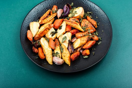 Healthy homemade roasted parsnip root, carrots and garlic.