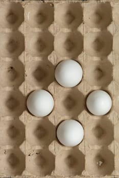 Four eggs in the cardboard box - top viewpoint, vertical shot
