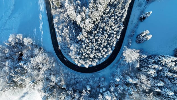 Drone photo of a sharp bend in the road with traffic in winter