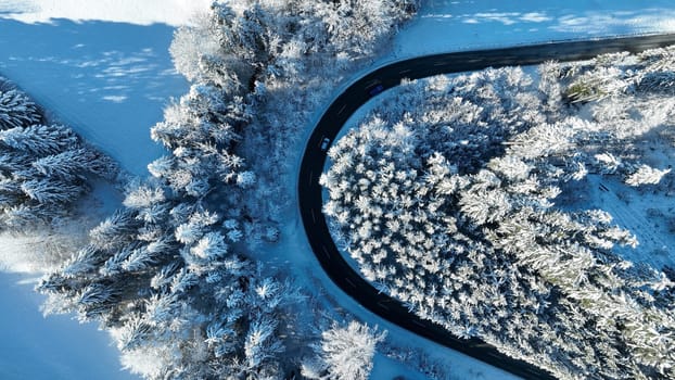 Drone photo of a sharp bend in the road with traffic in winter