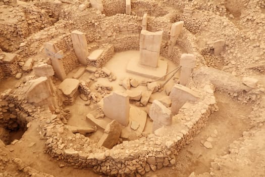 View onto Enclosure C at the neolithic archaeological site of Göbekli Tepe, Potbelly Hill, the central pillar 37 with a fox on it and the pillar 27 with a cat chasing a boar are clearly visible, close to Sanliurfa, Turkey 2022