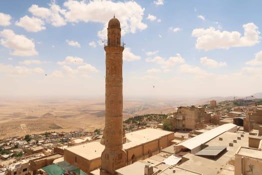 View onto the landscape of Syria from the old town of Mardin, with the minaret of the Great, Grand Mosque, Ulu Camii in the foreground, Mardin, Turkey 2022