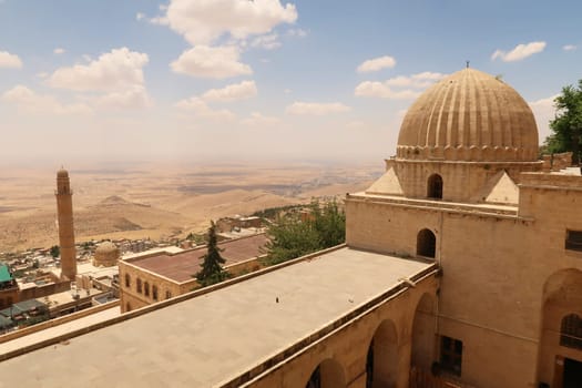 View from the Sultan Isa Medrese, Madrasa, Zinciriye Medrese onto the old town of Mardin with its Great, Grand Mosque, Ulu Camii and the landscape of Syria in the background, Mardin, Turkey 2022