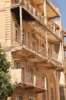 Elaborate traditional facade with many balconies on an apartment building in the old town of Mardin, Turkey 2022