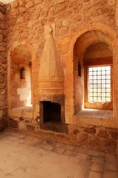 Room inside the ottoman Ishak Pasha Palace, Sarayi, barred windows and a traditiona chimney, Dogubeyazit, Turkey 2022