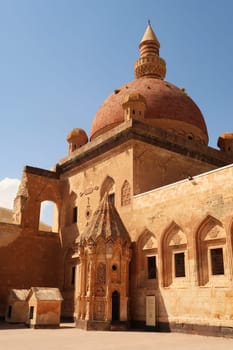 Ottoman tomb in front of a mosque with a red cupola, dome in the second court inside the Ishak Pasha Palace, Sarayi, Dogubeyazit, Turkey 2022