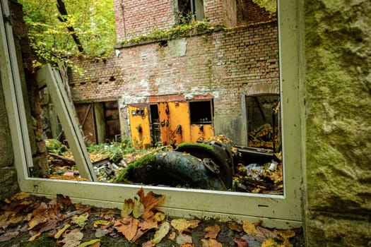 Lost place window of hydroelectric power plant with leaves