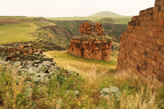 Ruins of the Hexagonal Church, Church of Abu'khanm next to a wall of the Citadel the ancient site of Ani, an abandoned ruined armenian city, close to Kars, Turkey 2022