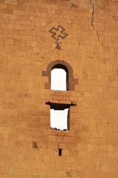 Cross symbol and two windows on the back of the tower next to the Lion Gate at the ancient site of Ani, an abandoned ruined armenian city, close to Kars, Turkey 2022
