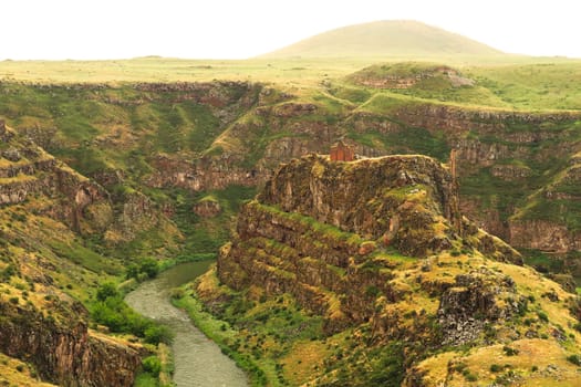 Spectacular view on the promontory encircled by the canyon of the Akhurian River with the ruins of the Church of Saint Elia, Zakares Church on top, last remaining building of the Kizkale, Kiz Kalesi, Maidens, Virgins Castle, ancient site of Ani, Kars, Turkey 2022