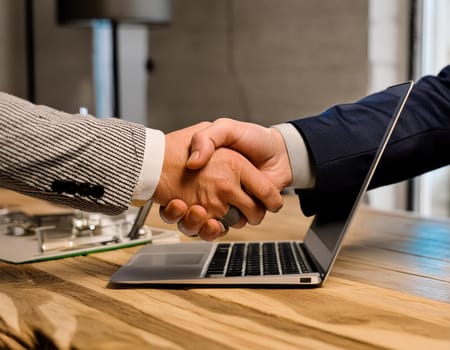 Handshake concept between a businessman and a person from the laptop screen.