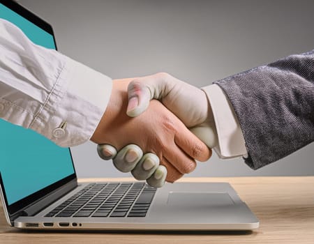 Handshake concept between a businessman and a person from the laptop screen.