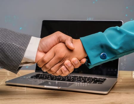 Handshake concept between a businessman and a person from the laptop screen.