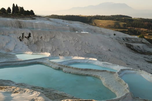 Intense turquoise blue water in the travertines of Pamukkale early in the morning, Denizli, Turkey 2022