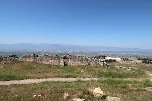 The town wall of the ancient site of Hierapolis with Pamukkale, the valley and the mountains in the background, Denizli, Turkey 2022