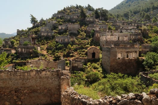 Ruins of houses on a hill in the abandoned village of Kayaköy, Livissi, close to Fethiye, Turkey 2022