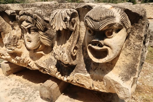 Big stone with ancient relief of three theater masks in the ancient town of Myra, near Demre, Turkey 2022