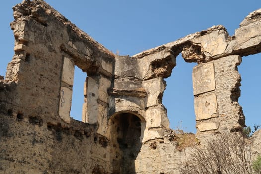 Leftover interior of one of the houses in the abandoned village of Kayaköy with chimney and windows, near Fethiye, Turkey 2022