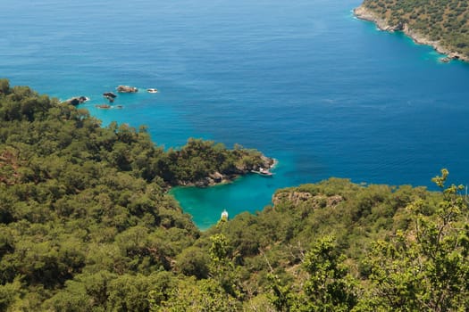View onto the turquoise colored Mersinli Koyu Bay with an anchored boat in it, near Kayaköy, Fethiye, Turkey 2022