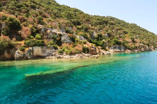Submerged wall next to remaining structures onshore at the ancient sunken city of Kekova, Kekova Island, Demre, Turkey 2022