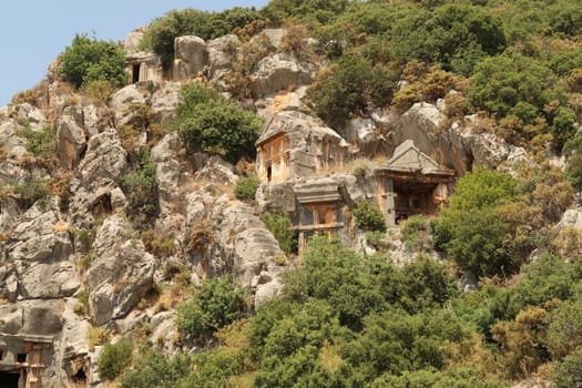 Rock hewn, rock cut lycian tombs high up on a cliff at the ancient site of Myra, close to Demre, Turkey 2022