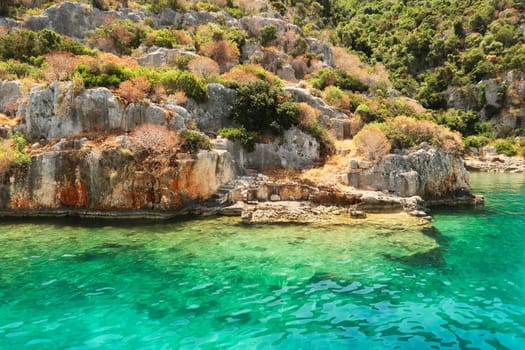 Stairs ending in the water next to submerged structures at the ancient sunken city of Kekova, Kekova Island, Demre, Turkey 2022