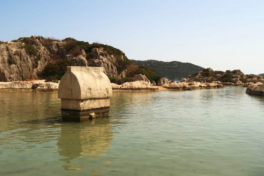 Sarcophagus standing in the shallow water close to the harbor of Kaleköy, close to Demre, Turkey 2022