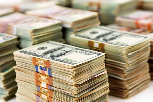 Multiple currency notes piled haphazardly, showcasing the clash of economies.