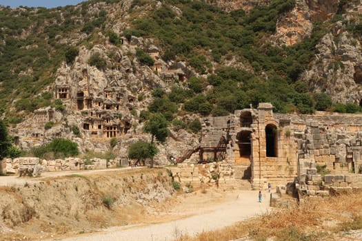 The ancient city of Myra with its rock-hewn tombs on the left and the entrance to its theater on the right, Demre, Turkey, 26th of May 2022