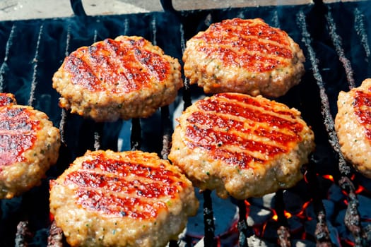 Burger patties grilled on the grill barbecue grate..