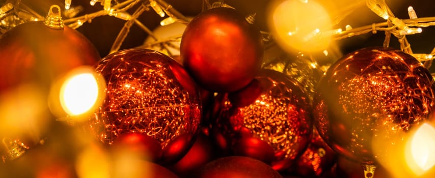 Close up of red Christmas balls baubles. Bokeh garlands. Xmas and holidays concept. Copy space and empty place for text, mock up greeting card.