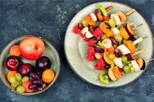 Colorful fruit skewers made from fresh fruits on wooden skewers.
